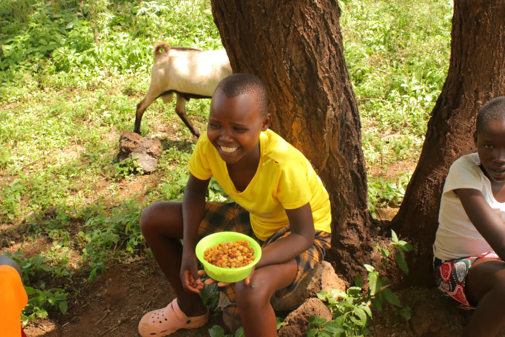 A Komolion boy enjoying his lunch provided by our school lunch program